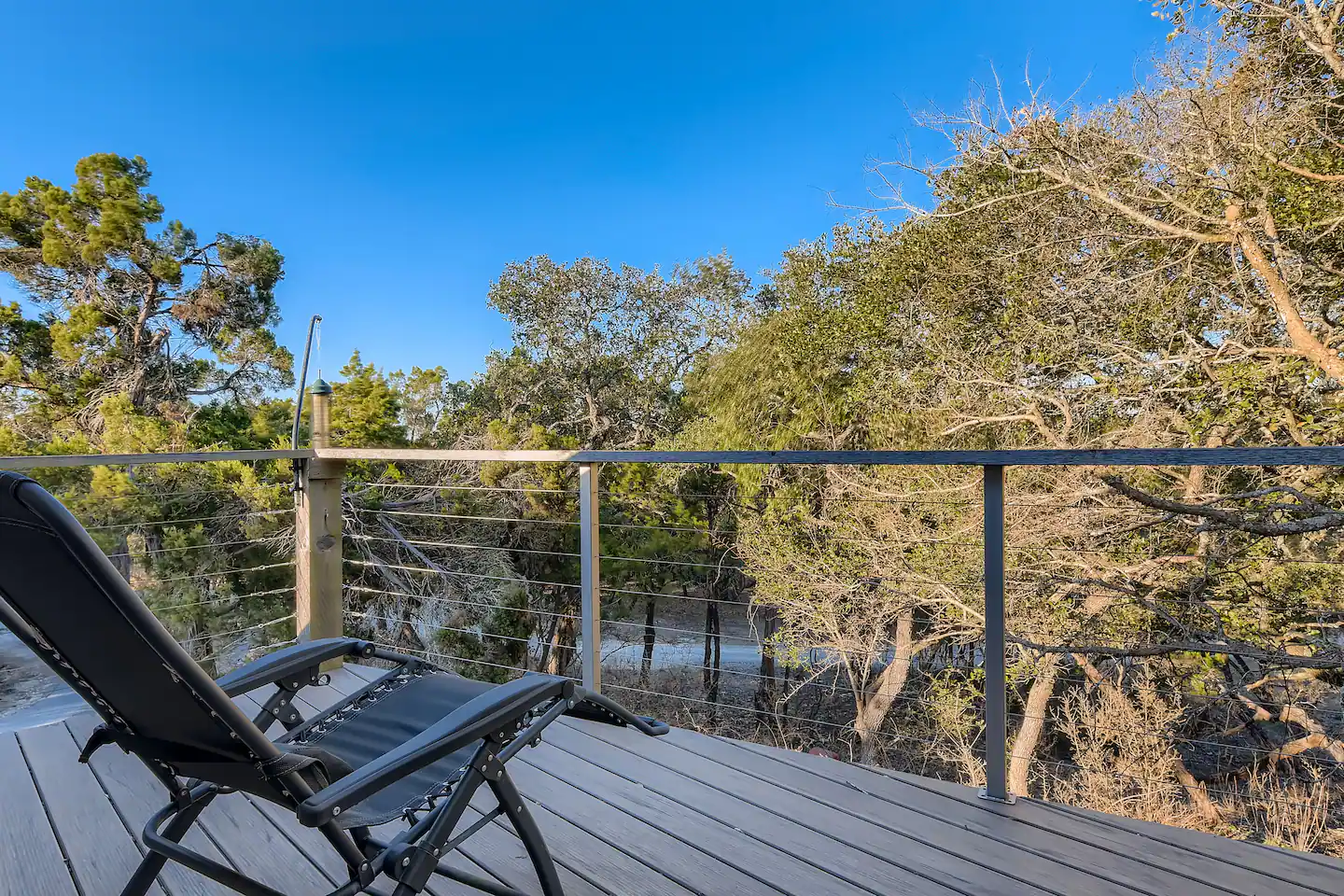 The Loft balcony with a lounge chair overlooking trees and surrounding nature.