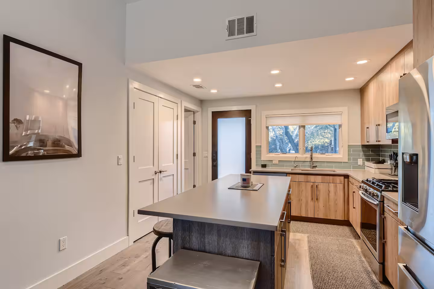 The Loft kitchen with wood cabinets, a large island, and stainless steel appliances.