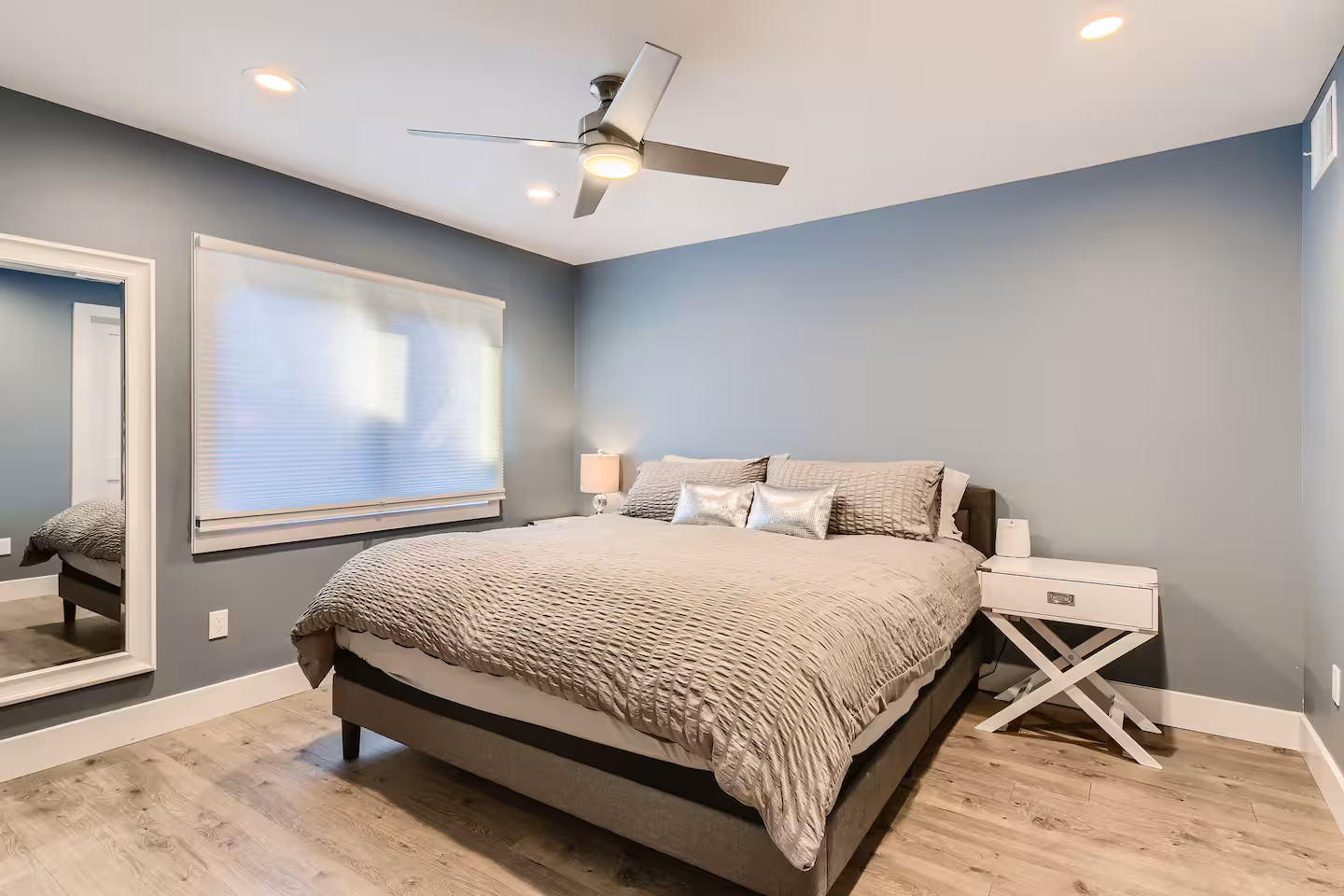 The Loft bedroom with a bed, ceiling fan, and soft gray walls.