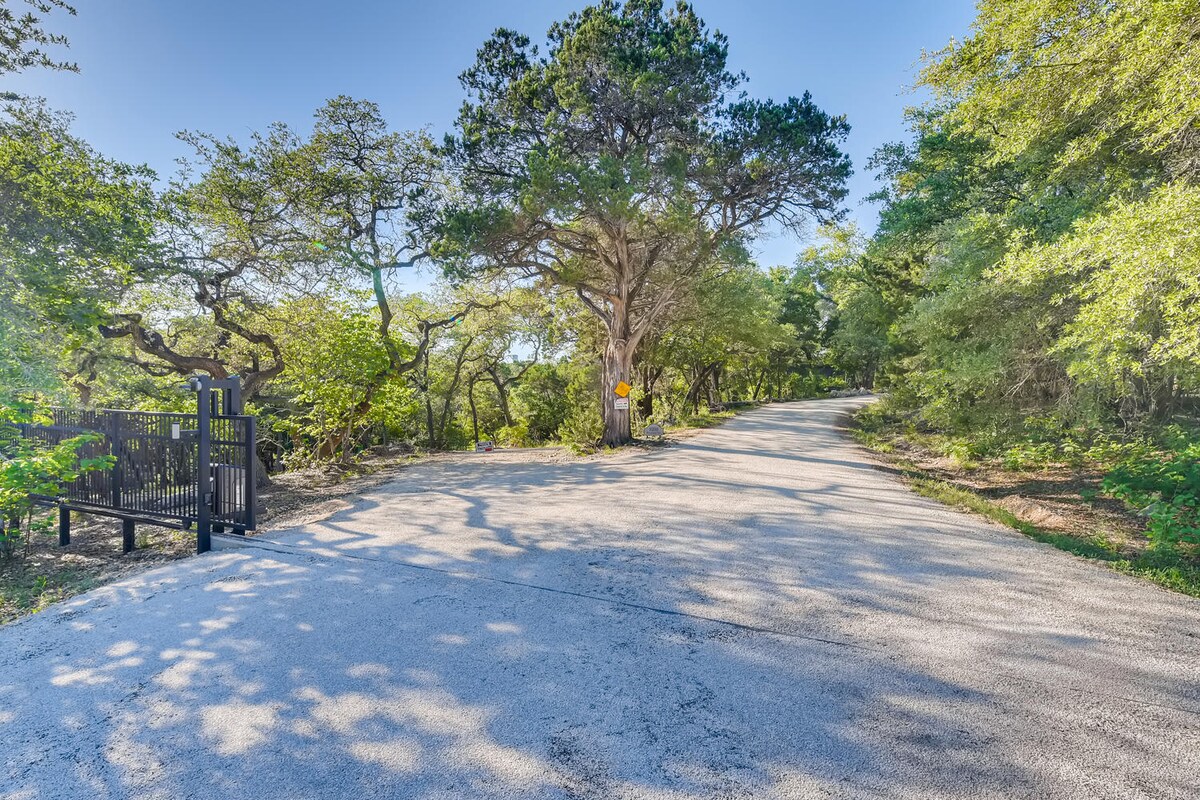 Tree-lined driveway entrance leading to The Cabin, surrounded by mature oak and pine trees