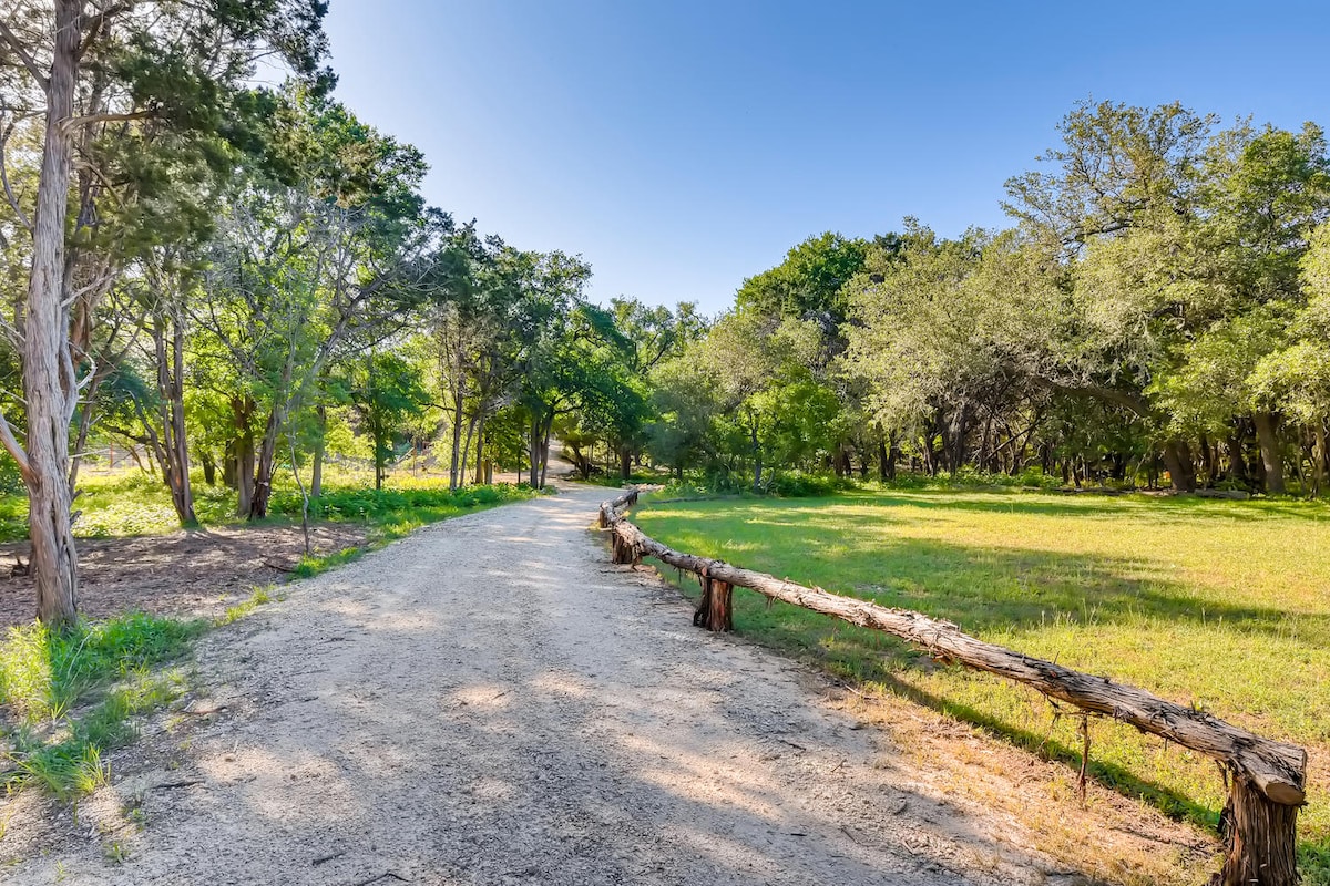 Wooded walking path near The Cabin with open grassy space and mature trees