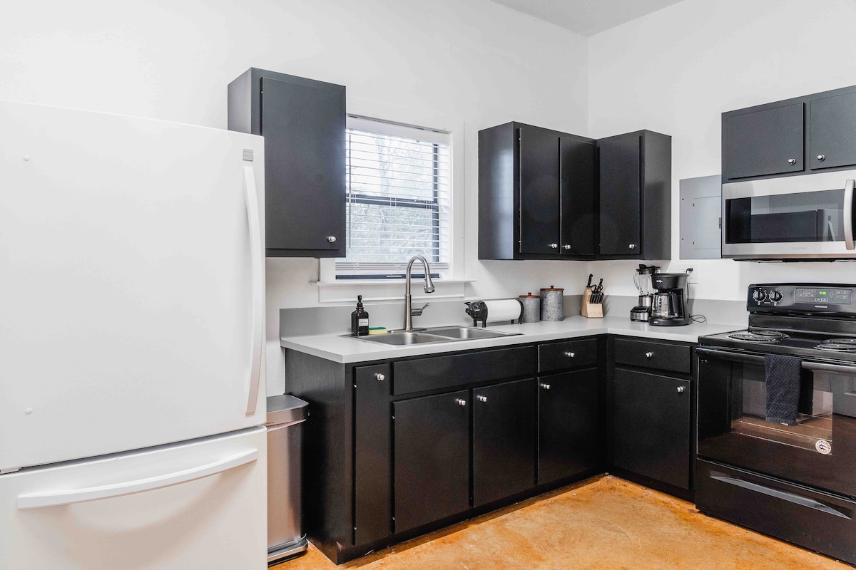 Casa Blanco secondary kitchen featuring black cabinetry, white appliances, and a clean, functional layout
