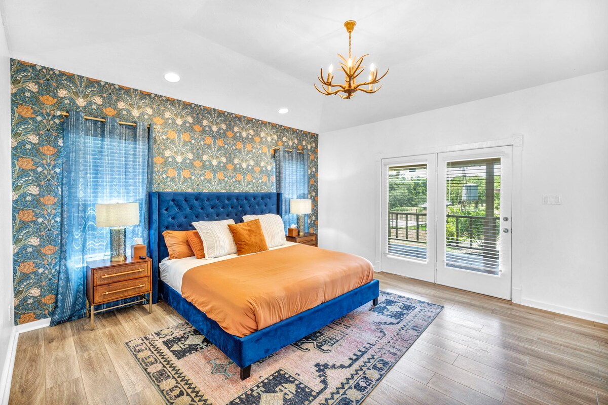Casa Blanco bedroom with blue upholstered bed and patterned accent wall