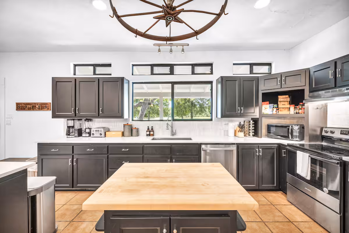 Casa Blanco kitchen with dark cabinets, center island, and modern appliances.