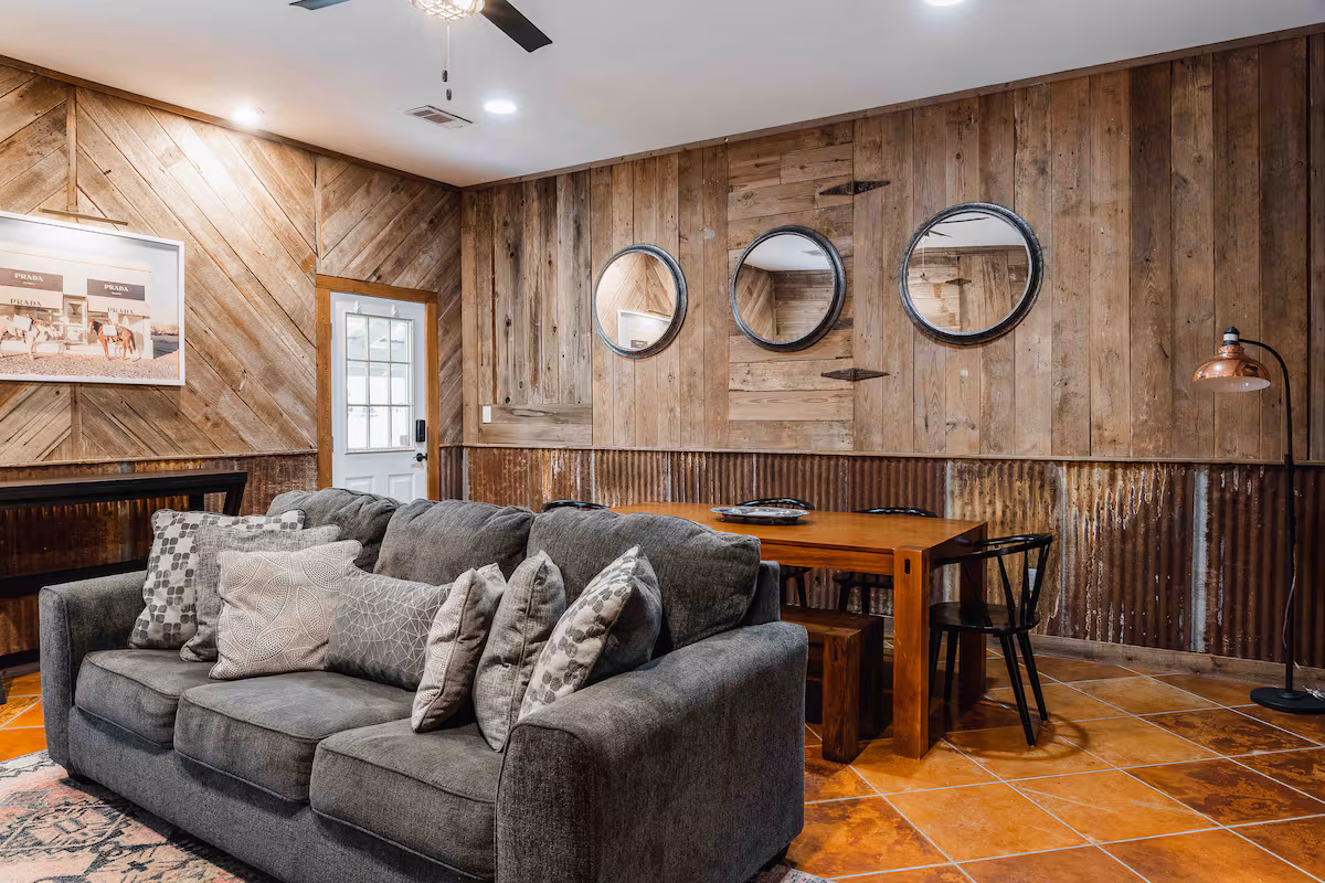 Cozy living and dining space at Casa Blanco with reclaimed wood walls, warm tile floors, and rustic-modern charm.