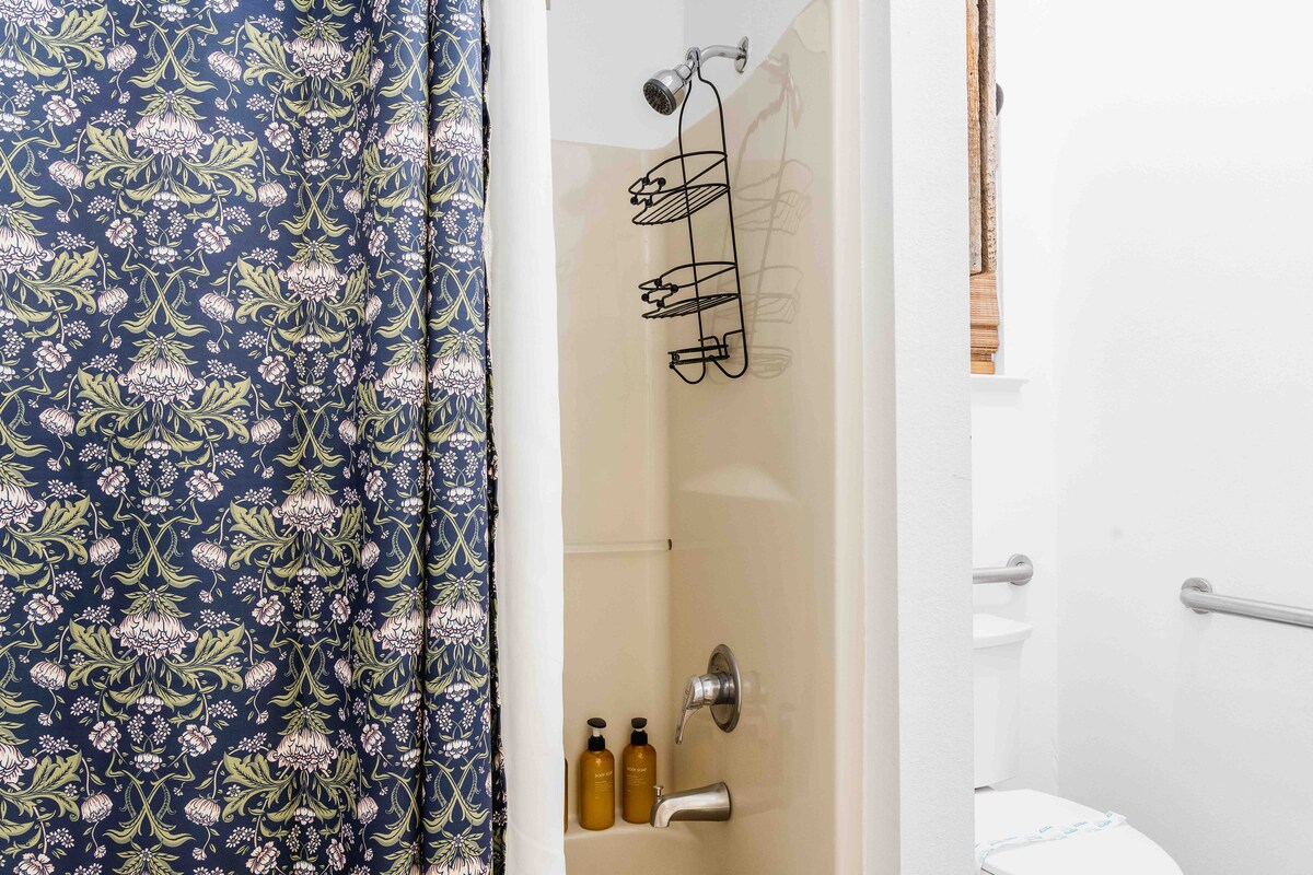 Casa Blanco bathroom with shower and patterned curtain.