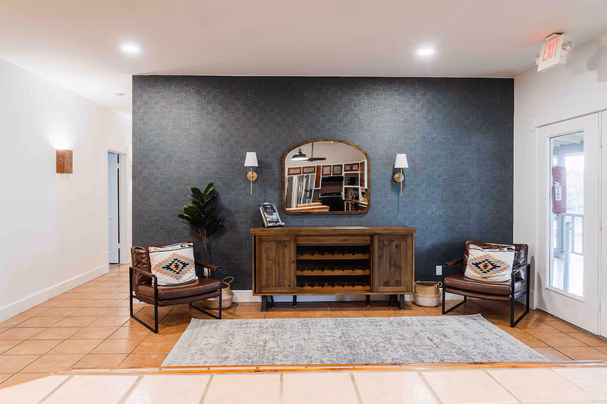 Casa Blanco seating area with console table, mirror, and accent chairs.