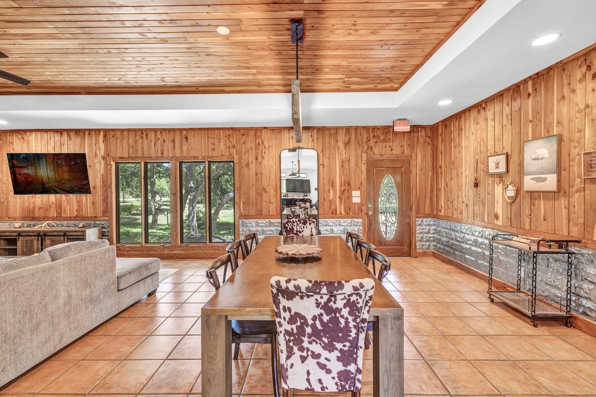 Casa Blanco dining area with long table and wood-paneled walls.