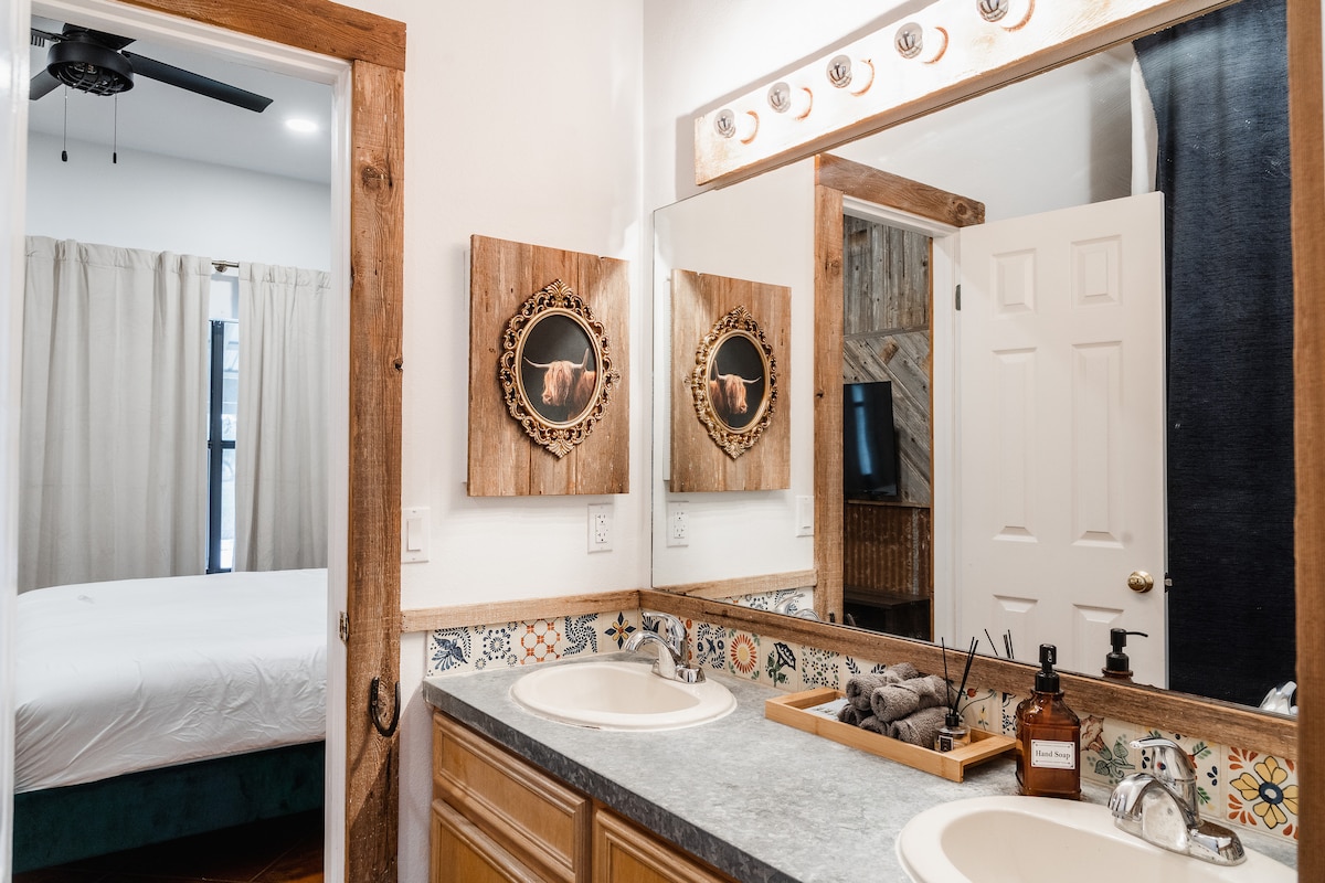 Cowboy Apartment bathroom with double sink vanity and rustic accents.