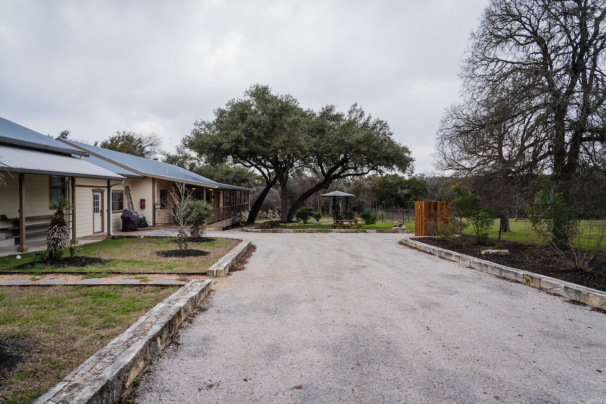 Cowboy Apartment exterior with gravel drive and outdoor gathering area.