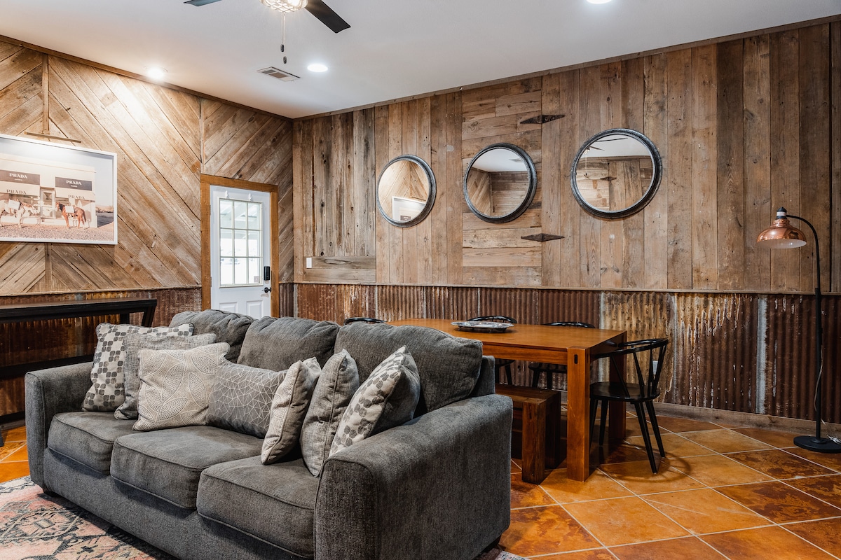 Cowboy Apartment living and dining area with rustic wood walls.