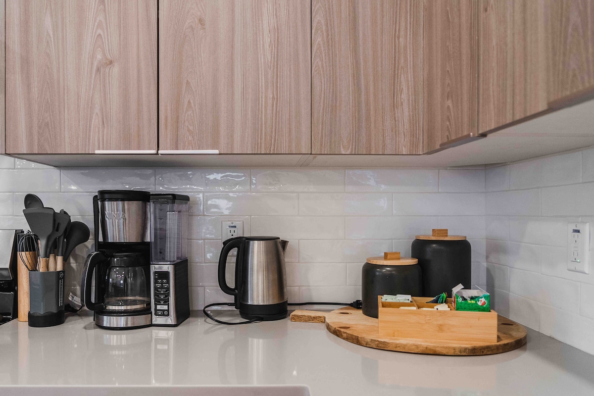 Modern kitchen counter at The Villa with coffee maker, kettle, and clean wood cabinetry.
