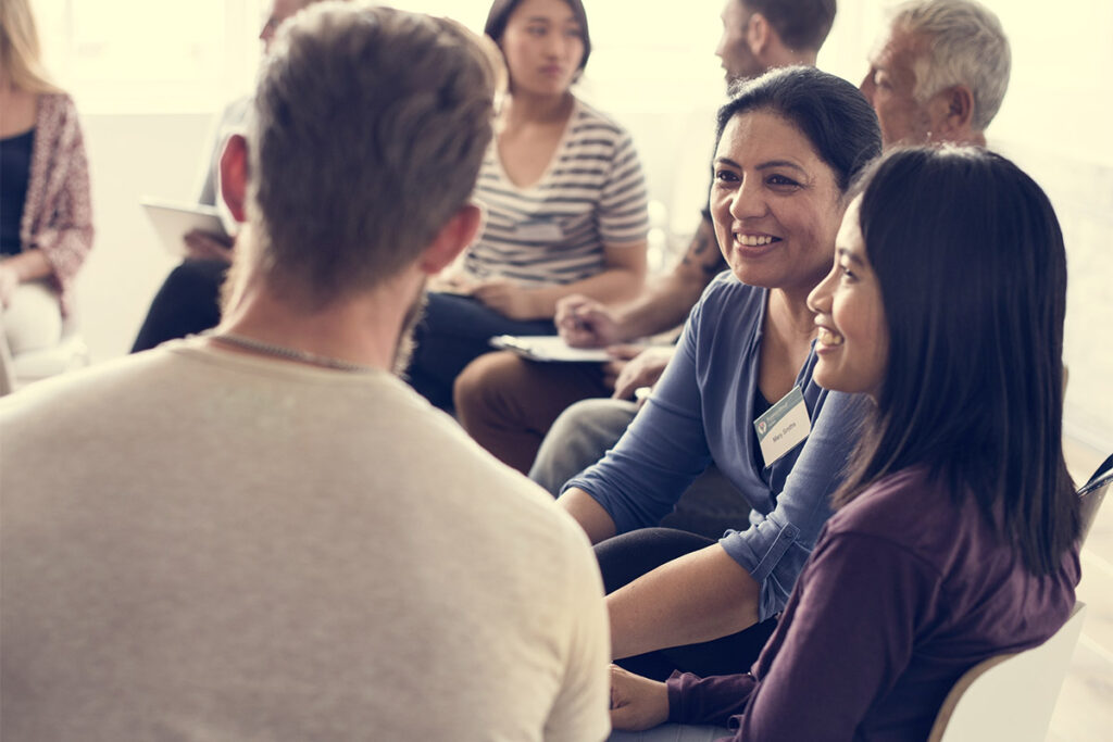 Participants engaged in a small-group discussion during an indoor workshop or retreat session.